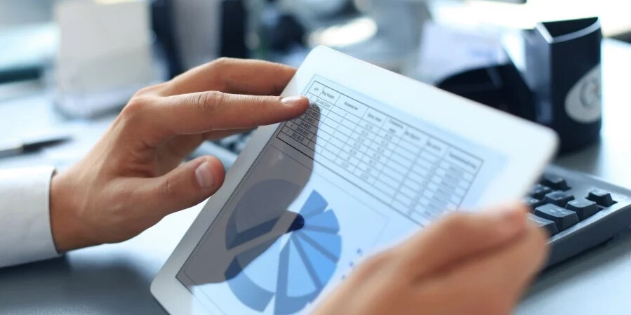 hand with tablet showing pie chart and data